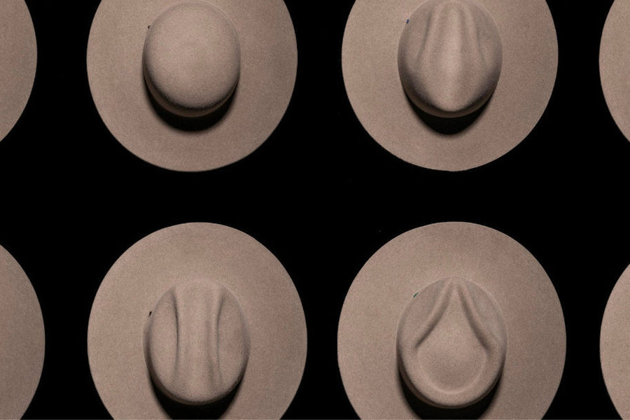 Various beige felt hats with different crown shapes on a black background