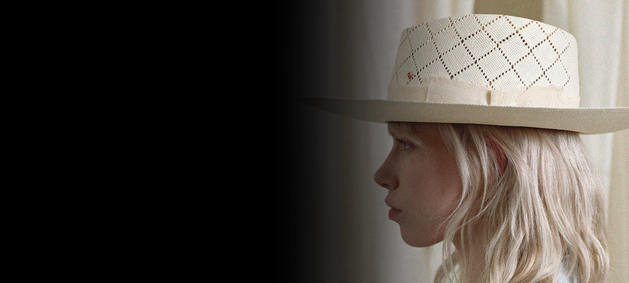 Woman in profile wearing a handmade Italian straw hat with cutout diamond pattern