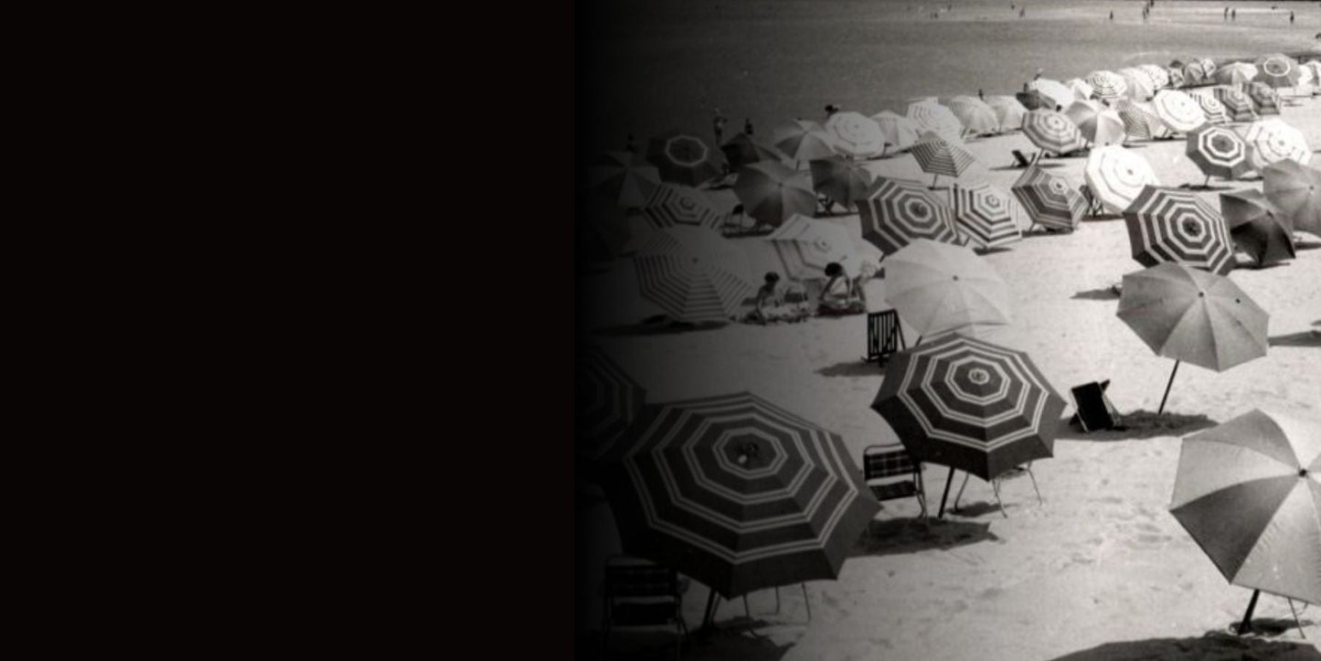 Vintage photo of striped beach umbrellas on sandy shore